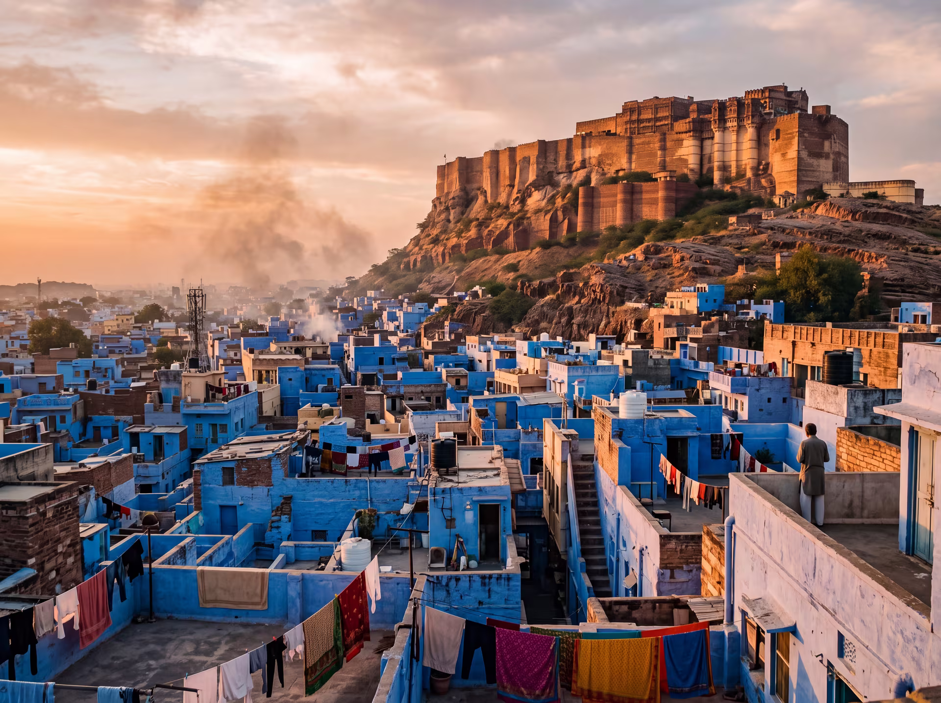 Indigo houses of Jodhpur's old town beneath Mehrangarh Fort at sunset