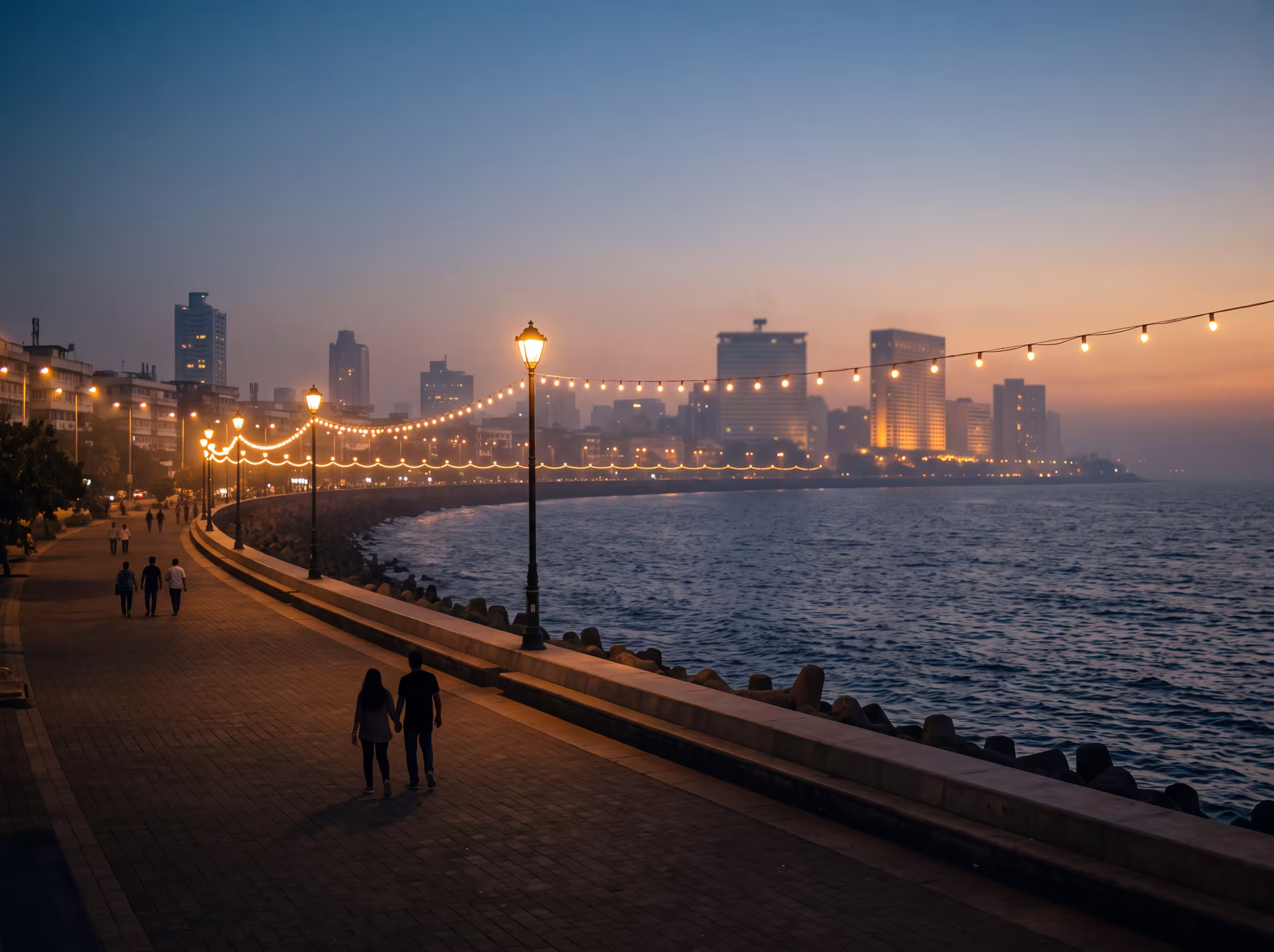 Marine Drive promenade in Mumbai at dusk, bay lights and silhouettes of passersby