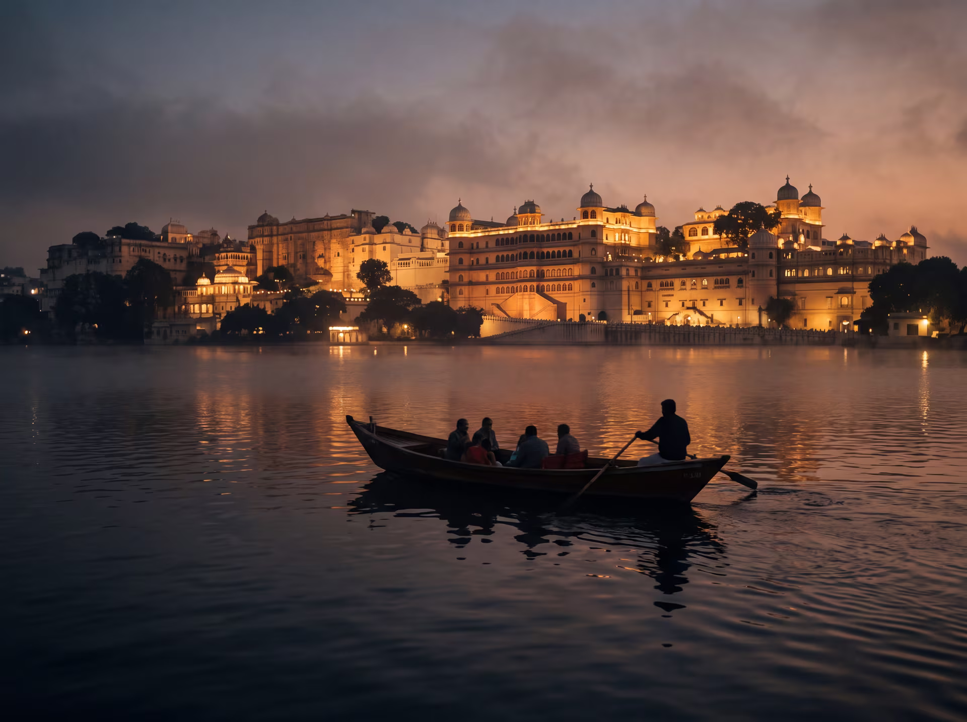 Boat gliding across Lake Pichola at dusk, Udaipur's City Palace golden in the background