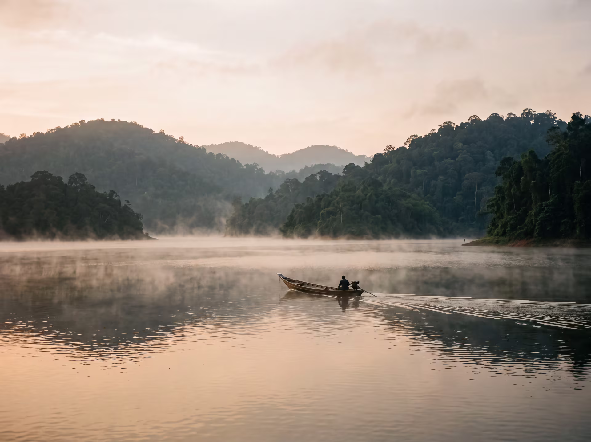 Bateau glissant sur le lac Temenggor entre des îles de jungle, parc Royal Belum