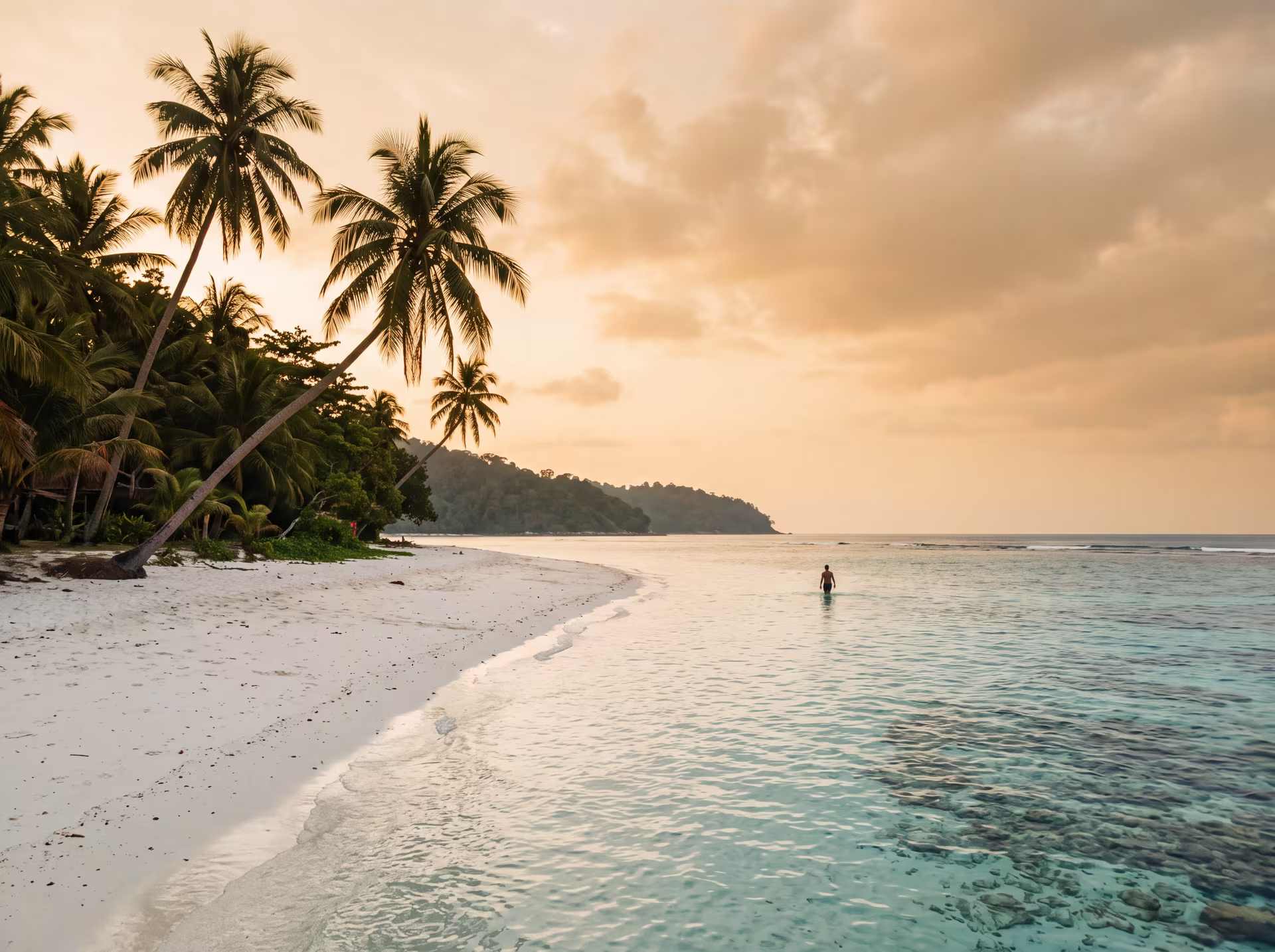 Plage de sable blanc et eaux turquoise des îles Perhentian, palmiers penchés sur le lagon