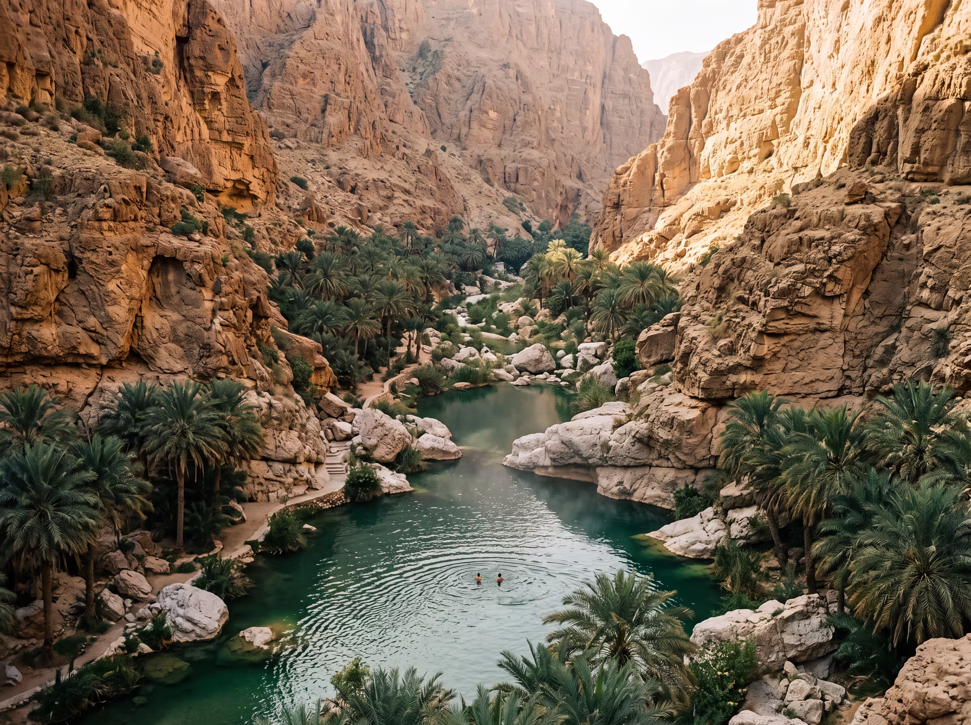 Vasques émeraude de Wadi Shab entre falaises et palmiers, baigneurs au loin dans la gorge