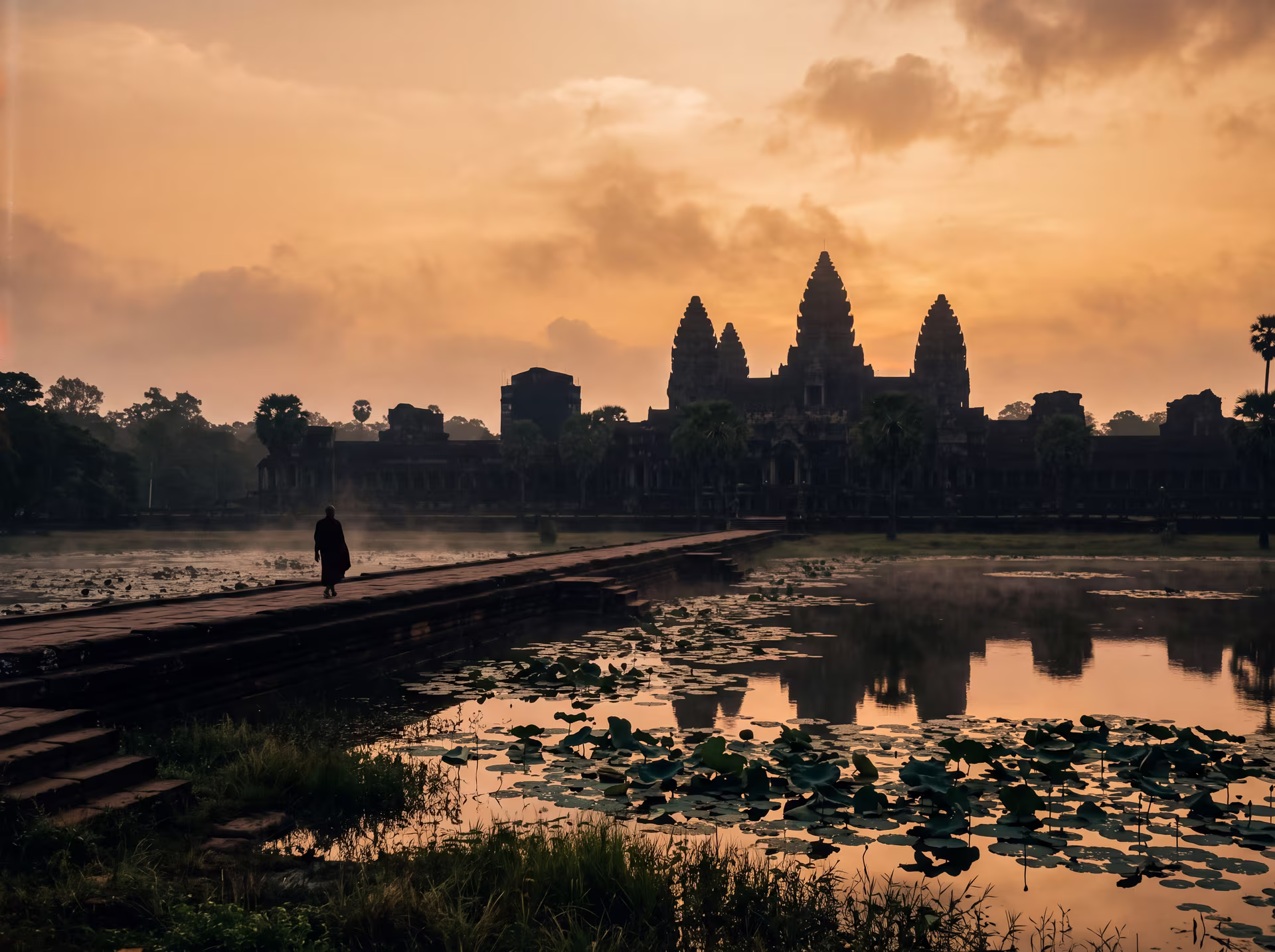 Türme von Angkor Wat als Silhouette bei Sonnenaufgang, Spiegelungen in den Wasserbecken