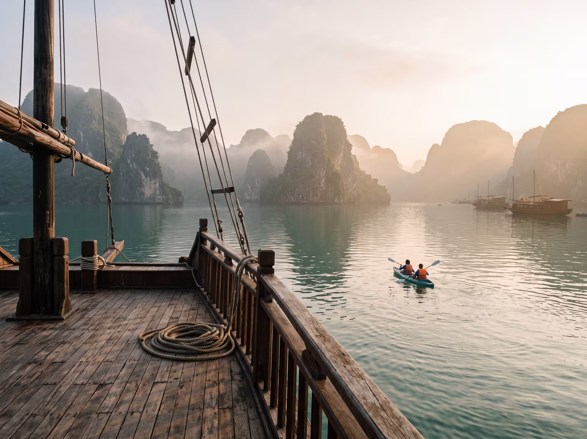Karstfelsen der Halong-Bucht ragen im Dunst aus smaragdgrünem Meer