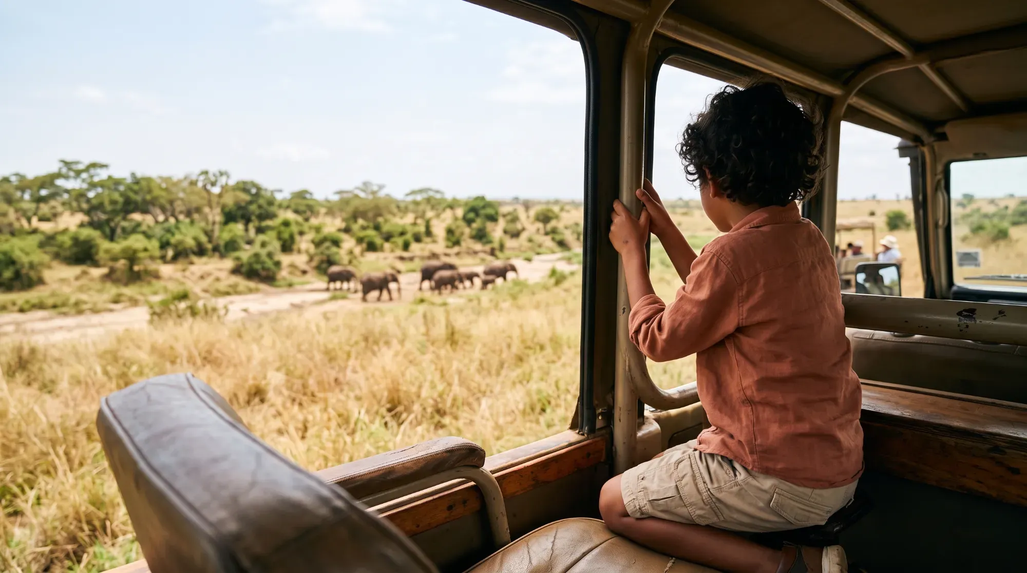 Enfant observant la faune sauvage lors d'un safari familial, illustrant une activité adaptée aux enfants