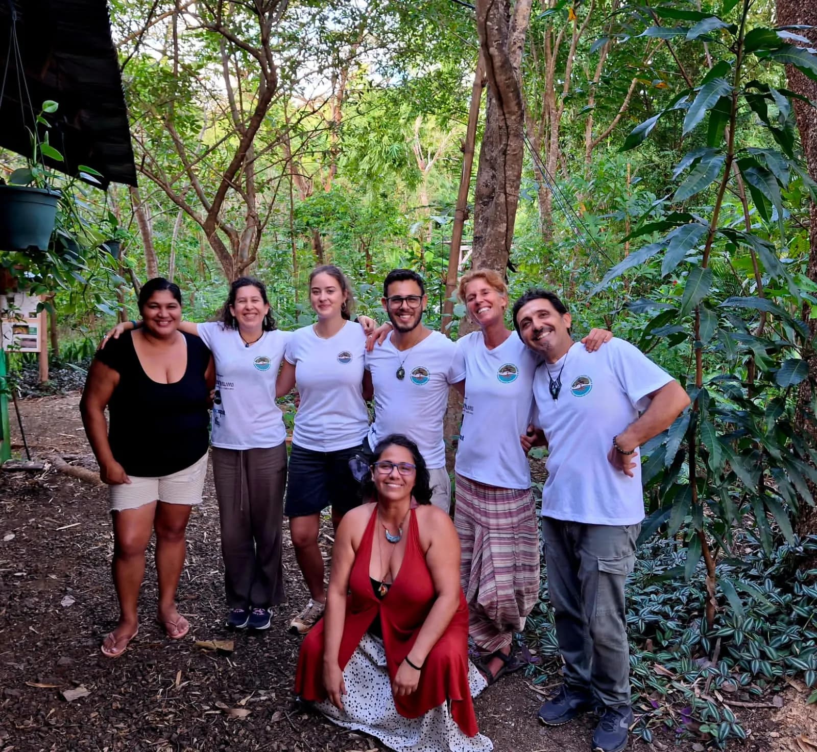 The Guanacaste Water Center team in white T-shirts with the center's emblem, smiling in the middle of the forest